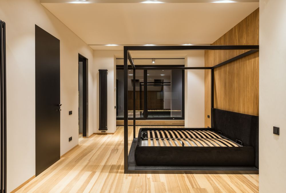 Illustrative dark four-poster bed frame with wooden slats