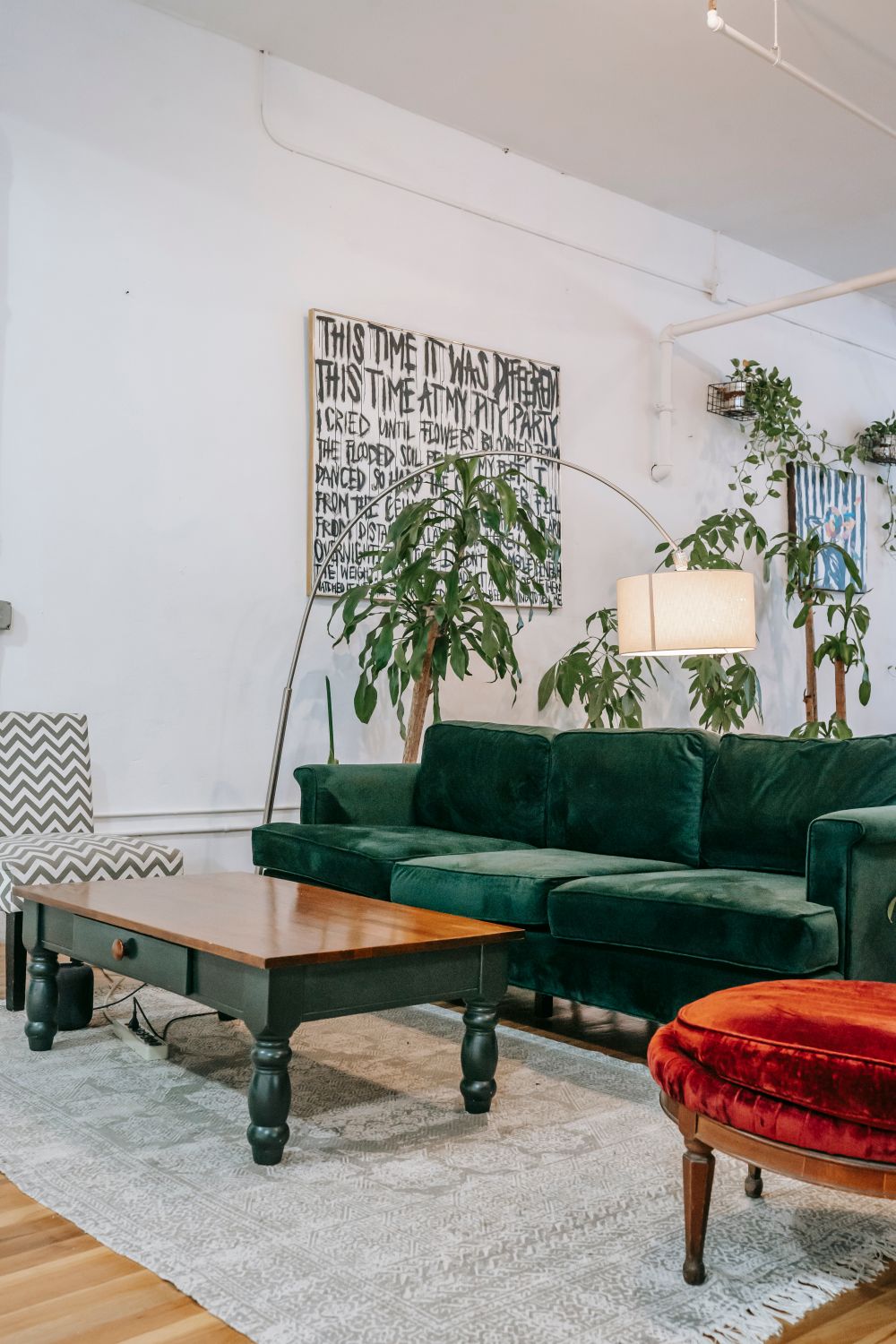 Illustrative green velvet sofa in a plant-filled living room